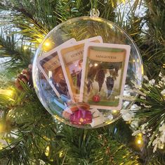 a christmas ornament hanging from a tree with cards in the middle of it