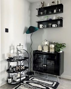 a black and white living room with shelves on the wall, a rug and a lamp