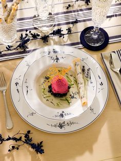 a white plate topped with food on top of a table next to utensils