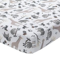 a baby crib sheet with giraffes and elephants on it