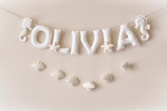 a white banner with the word lolivia spelled out in letters and seashells