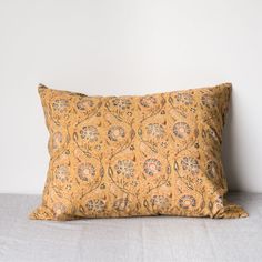 a yellow pillow sitting on top of a bed