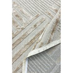 an area rug that has been placed on top of a white surface with grey and beige stripes