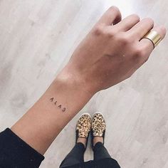 a woman's arm with a small tattoo on the left side of her wrist