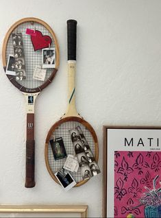 two tennis racquets mounted to the side of a wall with pictures on it