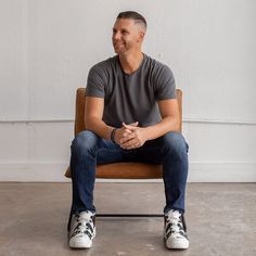 a man sitting on top of a wooden chair