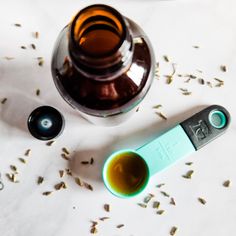 an electronic device next to a bottle of tea and some seeds on a white surface