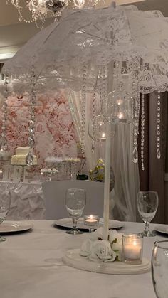 a white table topped with a chandelier and candles