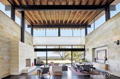 a large open living room with high ceilings and floor to ceiling windows