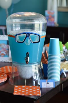 an ice cream machine with blue glasses on it's head and some paper plates