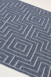 a blue and white rug sitting on top of a table