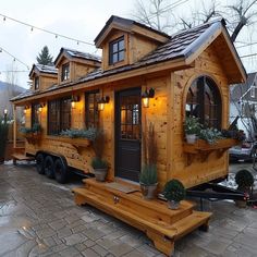 a small wooden house sitting on top of a brick floor next to a building with windows