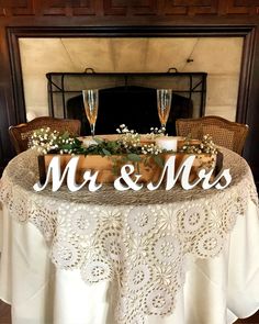 a table topped with two wine glasses and a mr and mrs sign on top of it