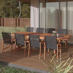 an outdoor dining table and chairs on a deck with sliding glass doors to the backyard