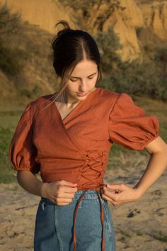 linen blouse, peasant blouse, linen wrap top for women, renaissance tops, linen shirt women, chemise, renaissance shirt A linen top is a stylish and comfortable garment made of light and breathable linen fabric. It has a design where one side of the top wraps around the body to create a flattering V-neck and is secured with laces. This type of top is known for its relaxed and casual chic look, making it a popular choice for casual outings or even semi-formal occasions. The natural texture of the Cheap Fall Linen Blouse, Luxury Cotton Blouse Piece For Designer Wear, Luxury Cotton Silk Blouse Piece For Designer Wear, Cheap Feminine Daywear Shirt, Going To Blouses, Cheap Modern Tops With Button Closure, Elegant Spring Dress Shirt, Luxury Elegant Summer Peasant Top, Luxury Cotton Peasant Top For Women