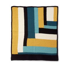 a black, yellow and blue rug with stripes on it's edges is featured against a white background