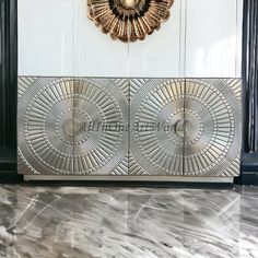 an art deco cabinet with two doors and a gold sun decoration on the wall behind it