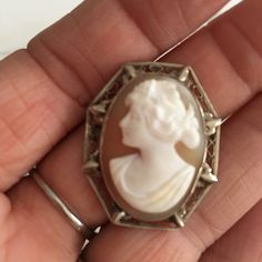 "14K white gold Small cameo. Very ornate, filigree setting holds a wonderful carved cameo of a beautiful Victorian women from the Edwardian era. This cameo can be both a brooch or a pendant. Brooch was made in the early 1900's and measures over 1 3/16\" in length X approximately 1\" in width. What makes this cameo so special is the fine detailed carving and wonderful delicate intricate frame, a tiny treasure. Shipping includes insurance. As always, local pickup is available. Aphrodite's Antique White Oval Brooch For Formal Occasions, White Cameo Brooch For Wedding, Victorian White Cabochon Brooches, White Cameo Brooch For Formal Occasions, White Victorian Cabochon Brooches, Antique White Brooch For Formal Occasions, White Cameo Brooches For Wedding, White Cameo Brooches For Formal Occasion, White Oval Cameo Brooches