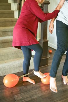 two people standing on the floor with orange balls