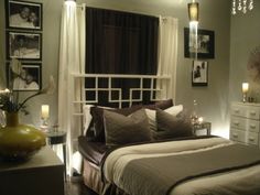 a bedroom with a large bed and pictures on the wall above it, along with candles