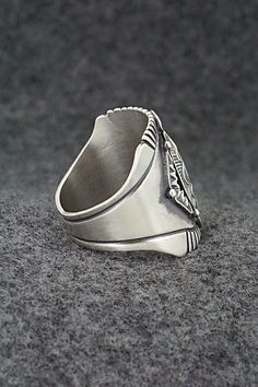 This finely crafted sterling silver ring was made by Navajo silversmith Derrick Gordon. The back is signed Derrick and stamped sterling.Size: 11Length: 1"Free shipping on all orders! We ship with USPS and always include tracking. All orders ship within a day of payment.Returns are accepted up to 30 days after you receive your order. Just send us a message. Our shop offers cash back or store credit. The item must be returned in new condition. Silver Sterling Silver Signet Ring, Engraved Sterling Silver Turquoise Ring, Artisan Engraved Silver Ring, Sterling Silver Stamped Turquoise Ring, Silver Concho Rings Perfect For Gifts, Southwestern Style Untreated Silver Rings, Stamped Sterling Silver Turquoise Ring, Silver Concho Rings For Gift, Artisan Engraved Silver Ring Collectible