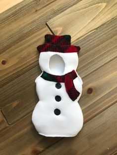 a snowman ornament hanging on a wooden table