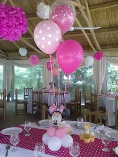 a minnie mouse balloon centerpiece on a table at a birthday party with pink and white balloons