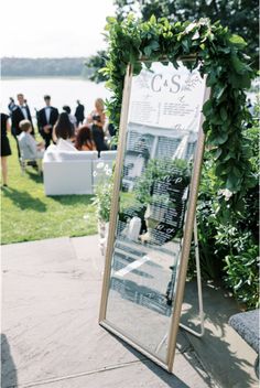 an outdoor ceremony with a large mirror on the ground and people in the background looking at it