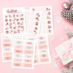 christmas stickers and gift on pink background with snowflakes, pine cones and ornaments