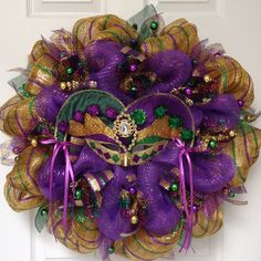 a purple and gold wreath with mardi gras decorations