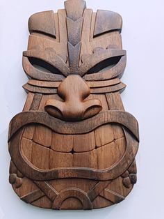 a carved wooden mask on display against a white background