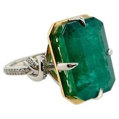 Glamorously bold and unabashedly seductive. This showstopper one of a kind ring features an intense 15ct natural Emerald poised between sharp eagle style talons and embraced by powerful-platinum, diamond encrusted ropes, converging to two knots on either side of the luscious, one-of-a-kind stone. Handcrafted in platinum and 22ct yellow gold 15ct Natural Zambian Emerald Emerald cut Comes with Valuation Over fifty highest quality white diamonds on the band Ethically sourced gold and platinum Customisation available please contact our customer service team for gold or stone variations. This OHLIGUER jewel & is ready to ship. Please contact our customer service team after purchase to discuss your size and track the production of your piece. Comes with Valuation. Emerald Ring With Diamonds, Vintage Tiffany, Zambian Emerald, Knot Ring, Emerald Engagement Ring, Emerald Jewelry, Zambia, Natural Emerald, Emerald Ring