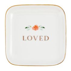 a white and gold plate with the word loved on it