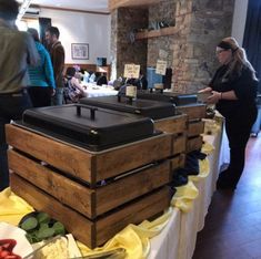 people standing around tables with food on them