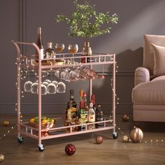 a bar cart filled with bottles and glasses on top of a wooden floor next to a couch