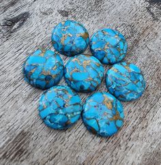 six blue rocks sitting on top of a wooden table