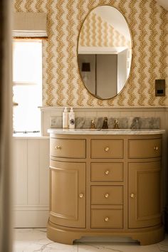 a bathroom with a sink, mirror and wallpapered walls in beige color scheme