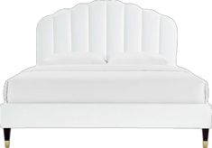 a white bed with two pillows on top of it