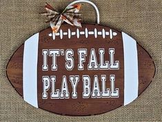 a wooden sign that says it's fall play ball with a football on it