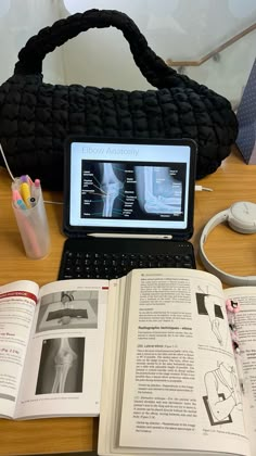 an open book sitting on top of a table next to a laptop computer and mouse