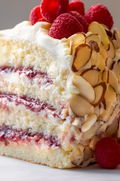 a piece of cake with raspberries and almonds on top