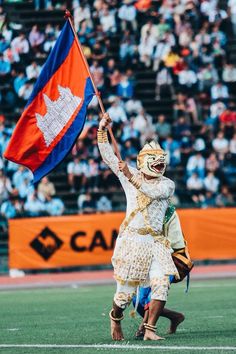 a man in costume holding a flag on top of a field