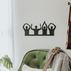 a guitar sitting on top of a green couch next to a wall mounted art piece