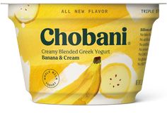 a yogurt container with bananas and cream on it's side, in front of a white background