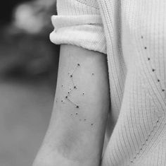 a woman's arm with a small star tattoo on it