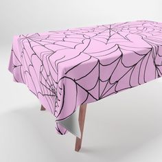 a pink table cloth with black lines on it and a spider web design in the center