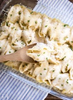 a casserole dish with dumplings in it and a wooden spoon