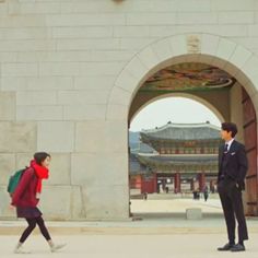 two people walking in front of an archway