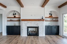 an empty living room with fireplace and built in shelves