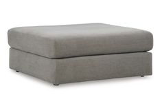 a grey ottoman sitting on top of a white floor